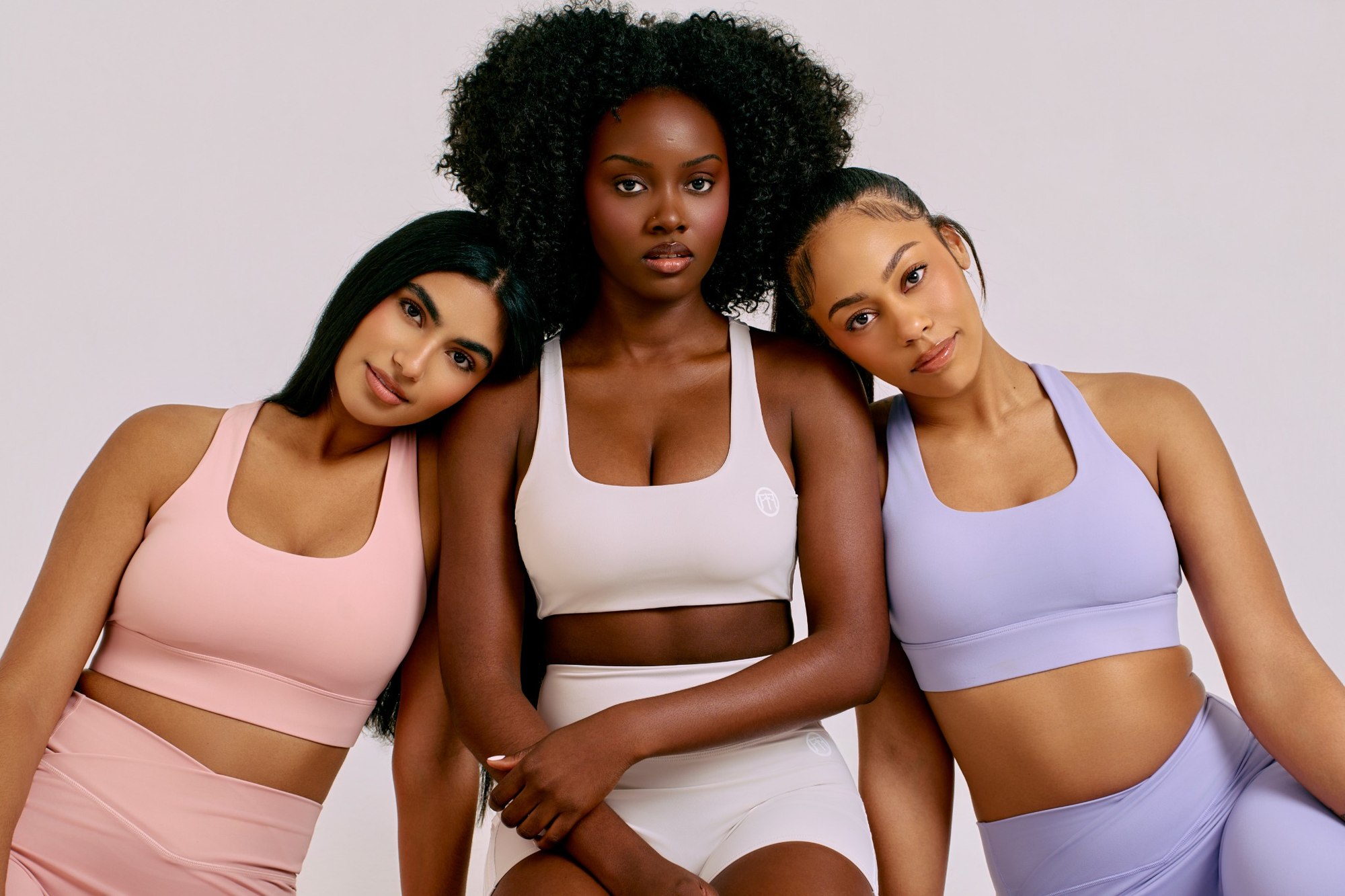 Three models wearing pastel activewear